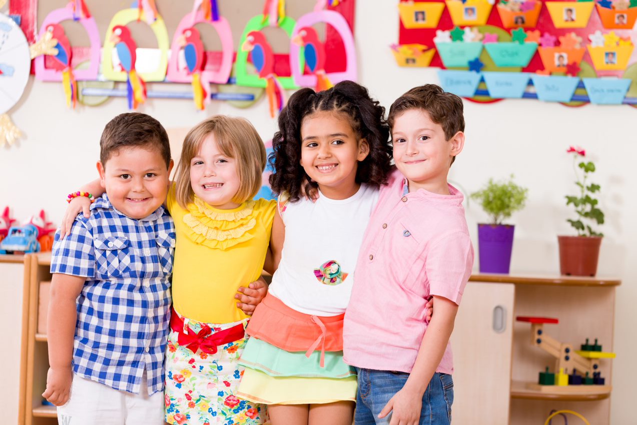 A group of children posing for a picture in a classroom.
