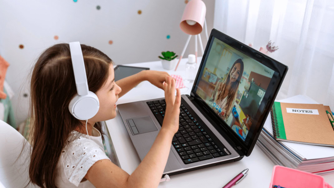 Young girl wearing headphones learning online.