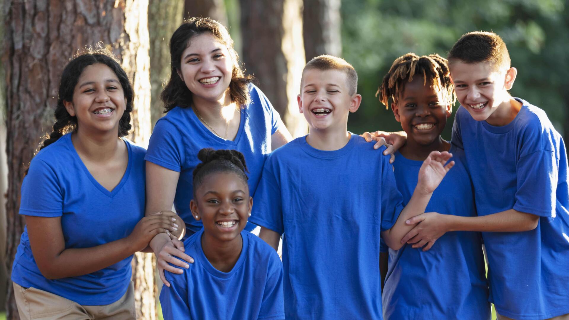 Kids in blue shirt posing for photo.