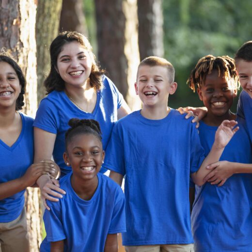 Kids in blue shirt posing for photo.